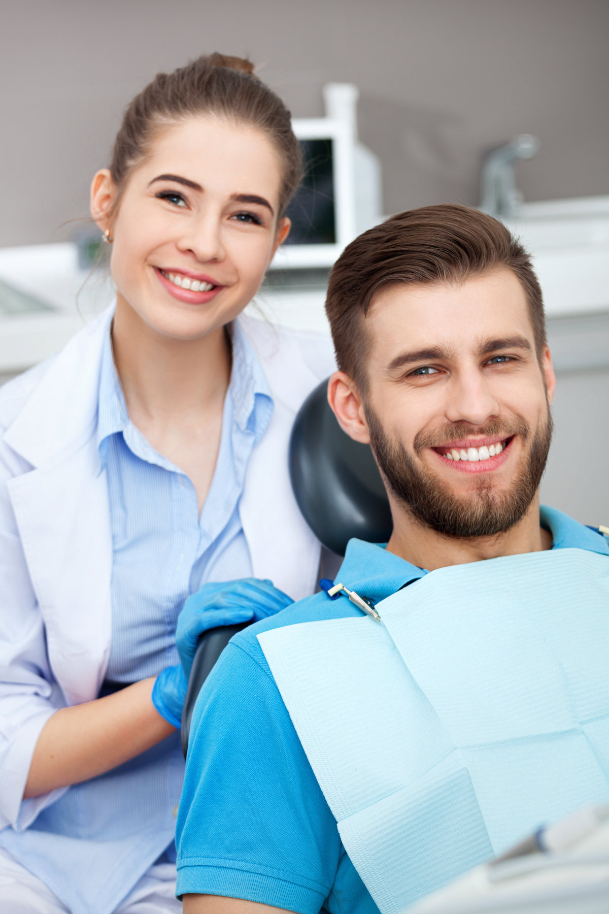 Portrait of a female dentist and young man in a dentist office. Portrait of a female dentist and young man in a dentist office.