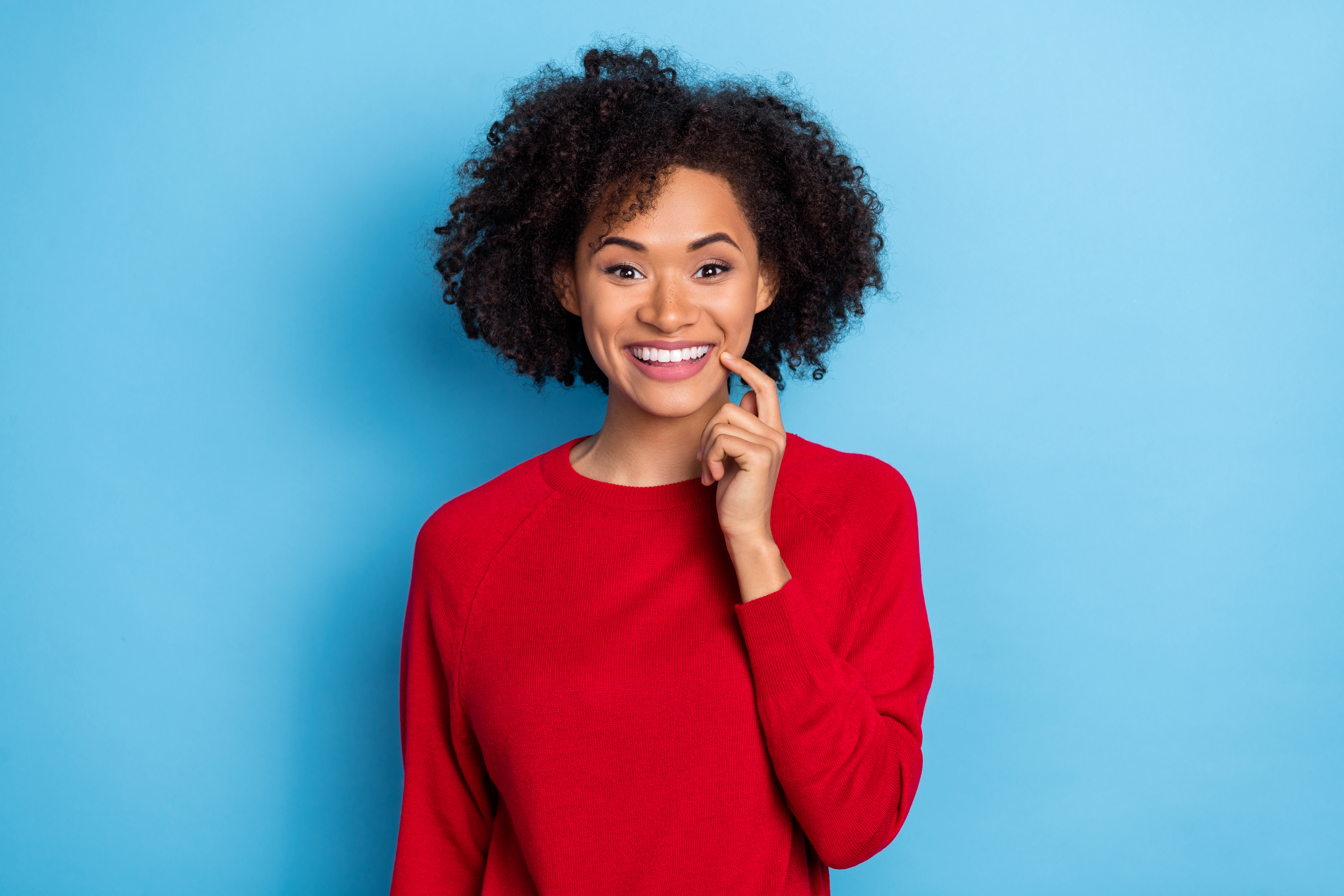 Photo of excited funny young lady dressed red pullover finger lips isolated blue color background Photo of excited funny young lady dressed red pullover finger lips isolated blue color background.