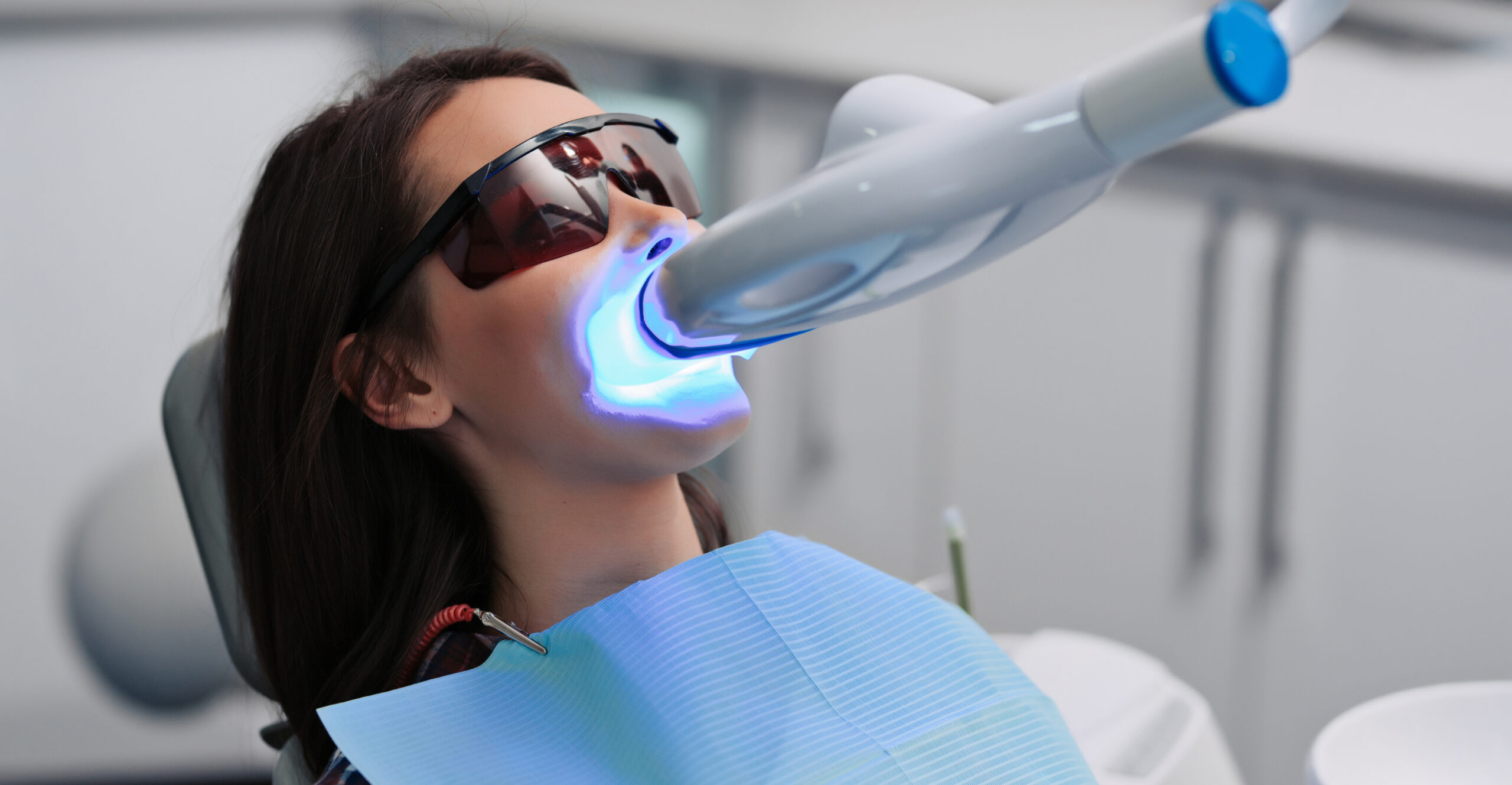 Teeth whitening for woman. Bleaching of the teeth at dentist clinic. Teeth whitening for woman. Bleaching of the teeth at dentist clinic.