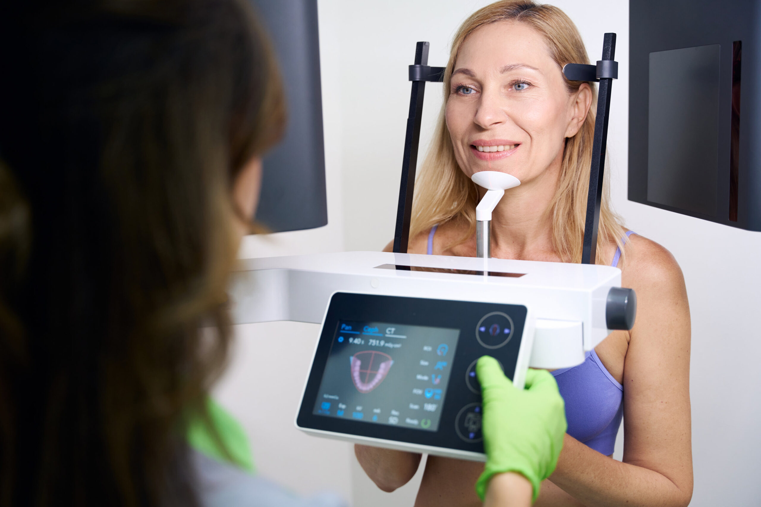 Adult woman receiving CBCT scan in dentistry clinic Patient undergoing dental cone-beam computed tomography carried out by experienced radiographic technologist