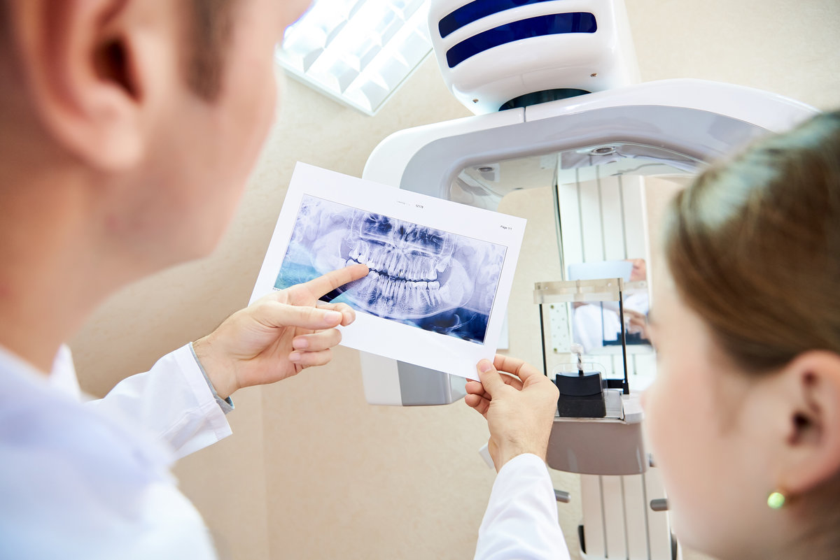 The doctor shows the patient an x-ray image. Computer diagnostics. dental tomography